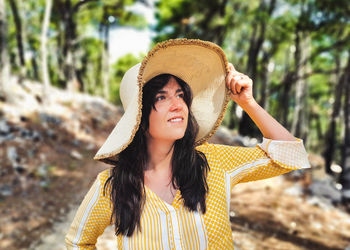 Portrait of beautiful young woman in yellow dress. hat, smile, positive emotion.