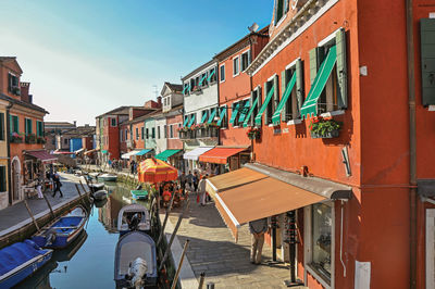 Colorful buildings and boats in front of canal at burano, a town full of canals near venice, italy.