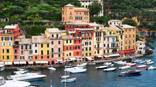 Boats moored on canal by buildings in city