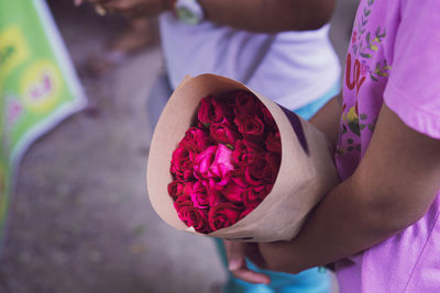 Midsection of woman holding rose bouquet