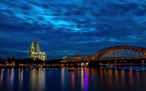 Illuminated bridge over river at night