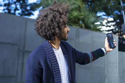 Young man taking selfie while standing in city