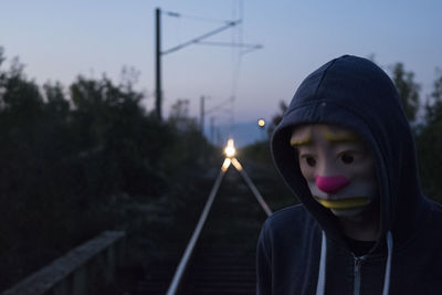 Close-up of man wearing mask against sky