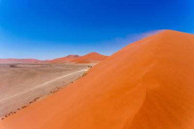 Scenic view of desert against clear blue sky