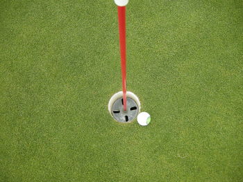 High angle view of golf ball by hole at course