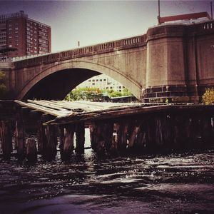 Bridge over river in city against clear sky