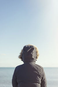 Rear view of woman looking at sea against clear sky