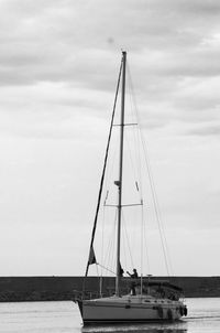 Sailboat sailing on sea against sky