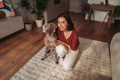 Portrait of young woman sitting on floor at home