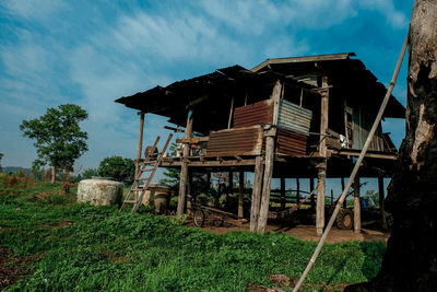 Abandoned house on field against sky