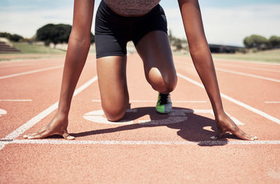 Low section of woman exercising on road