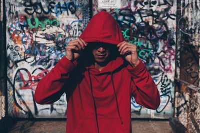 Man in hooded clothing standing in city