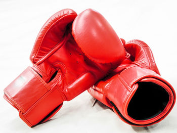 Close-up of red boxing gloves against white background