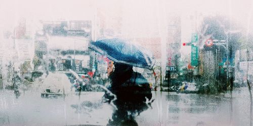 Reflection of man on glass window in rainy season