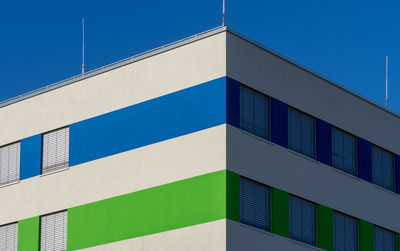 Low angle view of modern building against clear blue sky