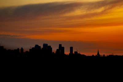 Silhouette buildings against sky during sunset