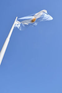 Low angle view of a flag against blue sky