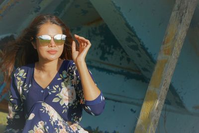 Woman wearing sunglasses sitting outdoors