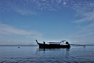 Man on boat in sea against sky