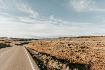 Road by landscape against sky