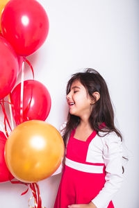 Smiling young woman holding balloons