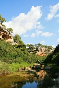 View of stream against cloudy sky