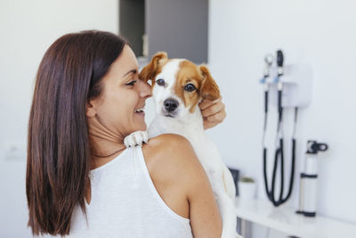 Rear view of veterinarian carrying dog