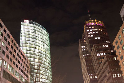 Low angle view of illuminated buildings against sky at night