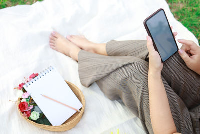 Midsection of woman using mobile phone