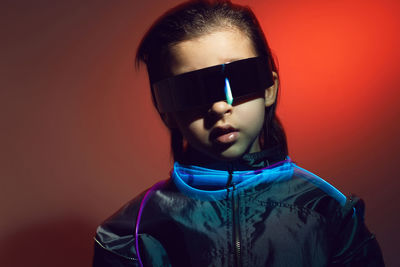 Portrait cyberpunk boy child in vr glasses in blue and red tones. game, virtual reality