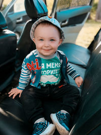 Portrait of cute boy sitting in car