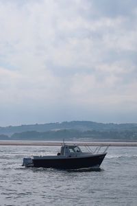 Boats sailing in sea against sky