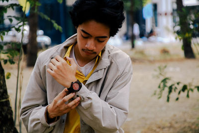 Man holding camera while standing outdoors