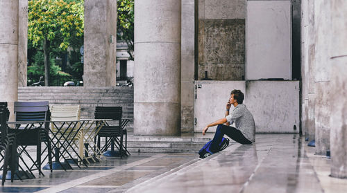 Side view of man sitting on bench