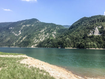 Scenic view of lake by mountains against clear sky