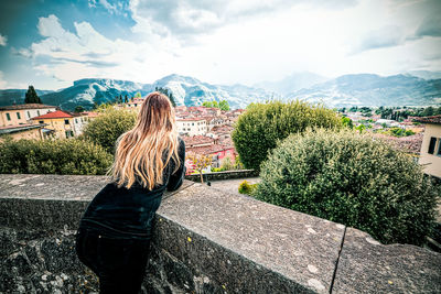 Rear view of woman looking at mountains against sky