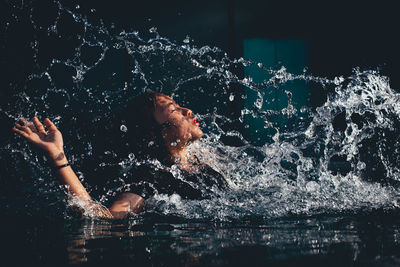 Woman swimming in lake at night