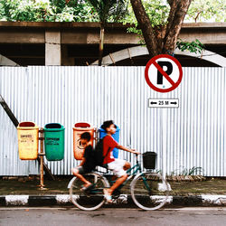 Man with bicycle sitting on road