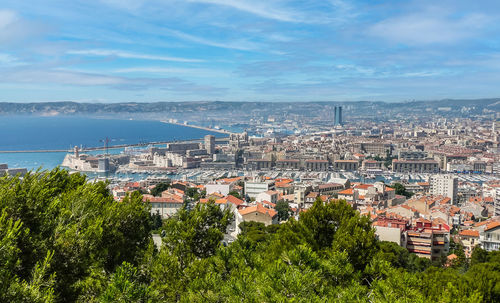 High angle view of townscape by sea against sky