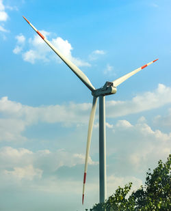Low angle view of windmill against blue sky