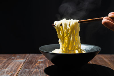 Close-up of hand holding ice cream in bowl