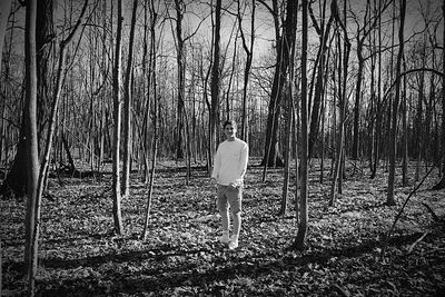 Rear view of woman standing in forest