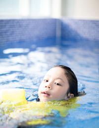 Close-up portrait of boy swimming in pool
