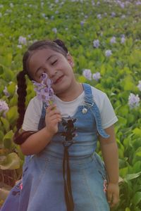 Cute smiling girl holding blue flowers