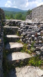 Steps leading towards mountain against sky