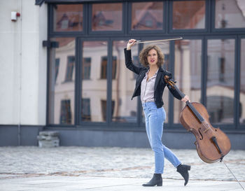 Full length of woman with violin on street