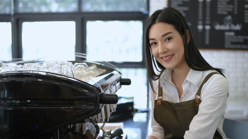 Portrait of smiling barista at cafe