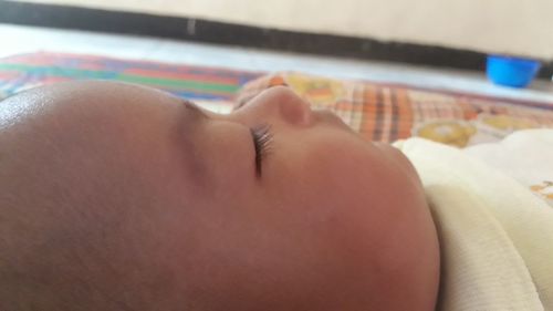 Close-up of baby sleeping on bed