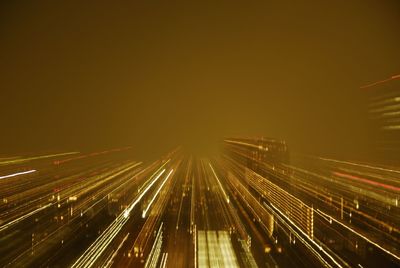 Light trails in city against sky at night