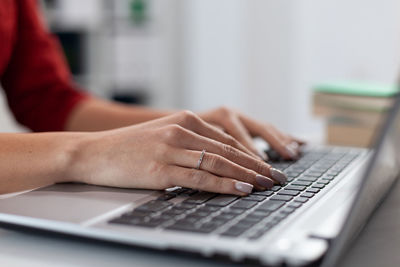 Cropped hands using laptop on table